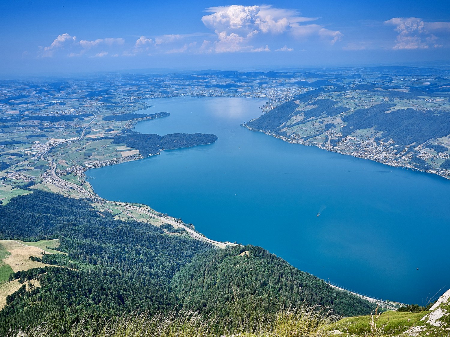 Blick auf die bewaldete Halbinsel "Chiemen" in der Bildmitte.